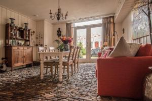 a living room with a table and chairs and a window at B&B "de Kleine Vesting" in Elburg