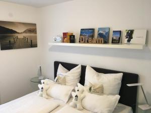 ein Schlafzimmer mit einem Bett mit weißen Kissen und Büchern in der Unterkunft Appartement Bergwaerts in Rickenbach