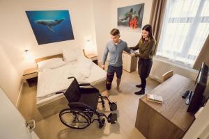 a man and a woman in a room with a wheelchair at Kings Residence in Prague