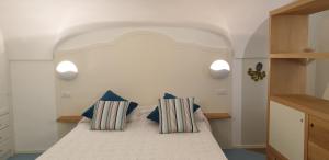 - une chambre avec un lit et deux oreillers dans l'établissement Arco della Rua, à Amalfi
