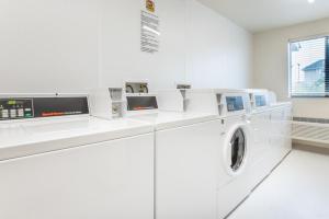 una lavanderia bianca con lavatrice e asciugatrice di My Place Hotel-Hurricane, UT a Hurricane