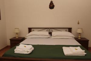 een slaapkamer met een bed met handdoeken erop bij La Mascherada in Ostuni