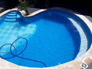 a blue swimming pool with a hose in it at Sentirse en casa in Puerto Iguazú