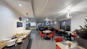 une salle à manger avec des tables et des chaises dans un restaurant dans l'établissement Kyriad Fontenay - Trésigny, à Fontenay-Trésigny