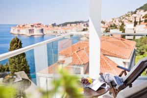 a balcony with a chair and a view of the water at Grand Villa Argentina in Dubrovnik