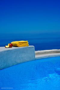 żółty ręcznik siedzący obok basenu w obiekcie Kifines Suites w mieście Chora Folegandros