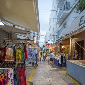 a street with shops and people walking down a street at Hostal Roca in San Antonio +12 photos