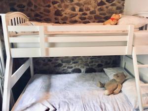 a bunk bed with a stuffed bear sitting on the bottom bunk at Forét Enchantée De Bourgogne in La Celle-En-Morvan