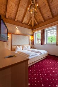 a bedroom with a bed and a desk and a television at Alpenapart Ladis im Sommer inkl Super Sommer Card in Ladis