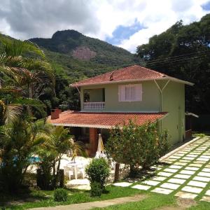 uma casa com uma palmeira em frente em Recanto dos Sonhos em Vargem