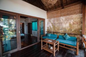 a living room with a blue couch and a table at Ferra Resort Siargao in General Luna