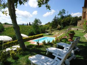 a group of lawn chairs next to a swimming pool at Borgo Fajani in Terricciola