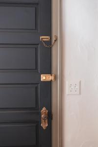 a black door with a gold latch on it at Stonehill's Farmhouse in Accord