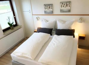 a white bed with white pillows in a room at Ferienwohnungen am Danewerk in Dannewerk