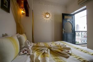 
a bedroom with a white bed and white curtains at Riad Matins De Marrakech in Marrakesh
