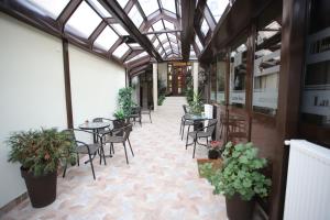 eine Terrasse mit Tischen und Stühlen in einem Gebäude in der Unterkunft Garni Hotel Laguna Lux in Niš