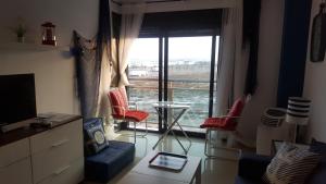- un salon avec une grande fenêtre offrant une vue dans l'établissement PLAYA SALINAS NUEVO CON PISCINA, à Roquetas de Mar