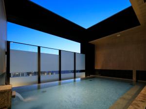 a large room with a swimming pool with a large window at Candeo Hotels Hiroshima Hatchobori in Hiroshima