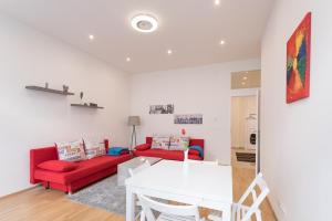 salon z czerwoną kanapą i białym stołem w obiekcie Bright Red Heart Apartment in Leopoldstadt w Wiedniu +35 zdjęć