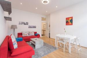 salon z czerwoną kanapą i stołem w obiekcie Bright Red Heart Apartment in Leopoldstadt w Wiedniu