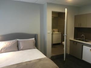 1 dormitorio con 1 cama y baño con lavamanos en MEDISTAY en Sídney