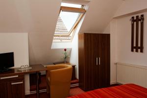 an attic room with a desk and a window at Pension Stejeris in Braşov