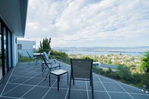 a balcony with chairs and a tennis court at Amazing Sea Views Luxury Guest House in Hobart