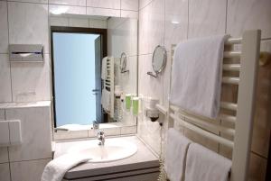 a bathroom with a sink and a mirror and towels at Parkhotel "Am Schänzchen" in Andernach