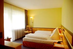a hotel room with a bed and a window at Parkhotel "Am Schänzchen" in Andernach +50 photos