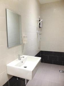 y baño con lavabo blanco y espejo. en SQUARE Inn en Taiping