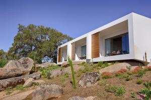 a house on the side of a hill with rocks at Monte Velho Equo-Resort in Arraiolos