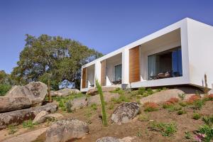 une maison sur le flanc d'une colline avec des rochers dans l'établissement Monte Velho Equo-Resort, à Arraiolos