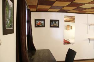 a room with a table and paintings on the wall at Hospedaje Los Ponchos in Otavalo