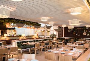 a dining room with tables and chairs and chandeliers at Glen Hotel and Suites in Brisbane