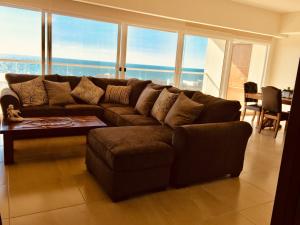 a living room with a brown couch and a table at La Jolla Excellence, Exclusive Front Beach! in Rosarito