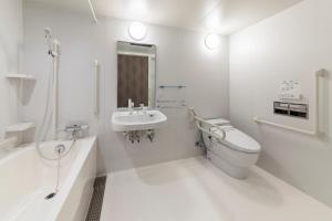 a white bathroom with a toilet and a sink at SARASA HOTEL Dotonbori in Osaka +36 photos