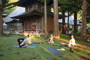 野沢温泉村にあるLodge Naganoの家の前の芝生に座る人々