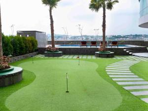 a golf course with palm trees and a putting green at HARRIS Hotel Sentraland in Semarang