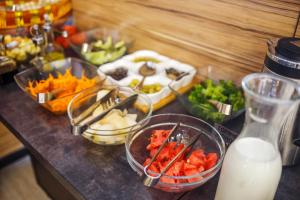 a counter with bowls of vegetables and a jug of milk at Solutel Hotel in Bishkek