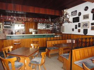 a restaurant with wooden tables and chairs and a bar at Zur Kringelwies in Masburg