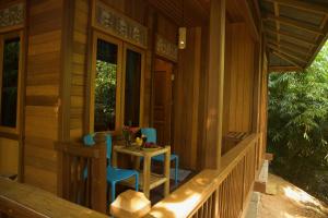 un porche de una casa con 2 sillas y una mesa en Nomad Divers Bangka, en Manado
