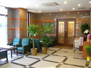 una zona de espera con sillas y plantas en un edificio en Hotel Route-Inn Oita Ekimae en Oita