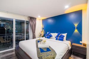 um quarto com uma cama grande e uma parede azul em Anchan Hotel & Spa em Hua Hin