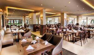 un ristorante con tavoli e sedie in una stanza di Tusan Beach Resort - All Inclusive a Kusadası