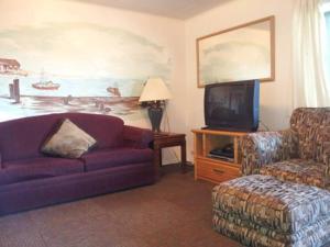 uma sala de estar com um sofá roxo e uma televisão em Ocean Avenue Inn em Westport