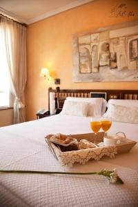 a tray of food and two drinks on a bed at Hotel Eli-Mar in A Guarda