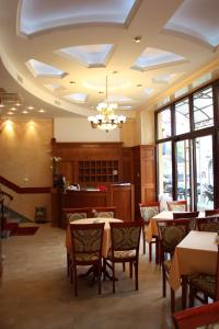 un comedor con mesas y sillas y una lámpara de araña en Garni Hotel Beograd, en Negotin