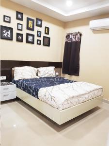 a bed in a bedroom with pictures on the wall at Babukala Regency in Kanchipuram