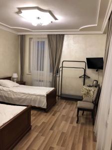 a hotel room with two beds and a chair at cozy apartments in Truskavets