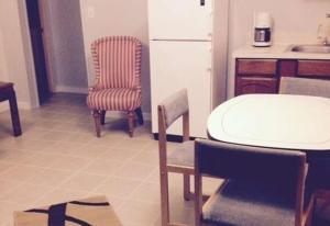 a kitchen with a table and chairs and a refrigerator at Ocean Avenue Inn in Westport